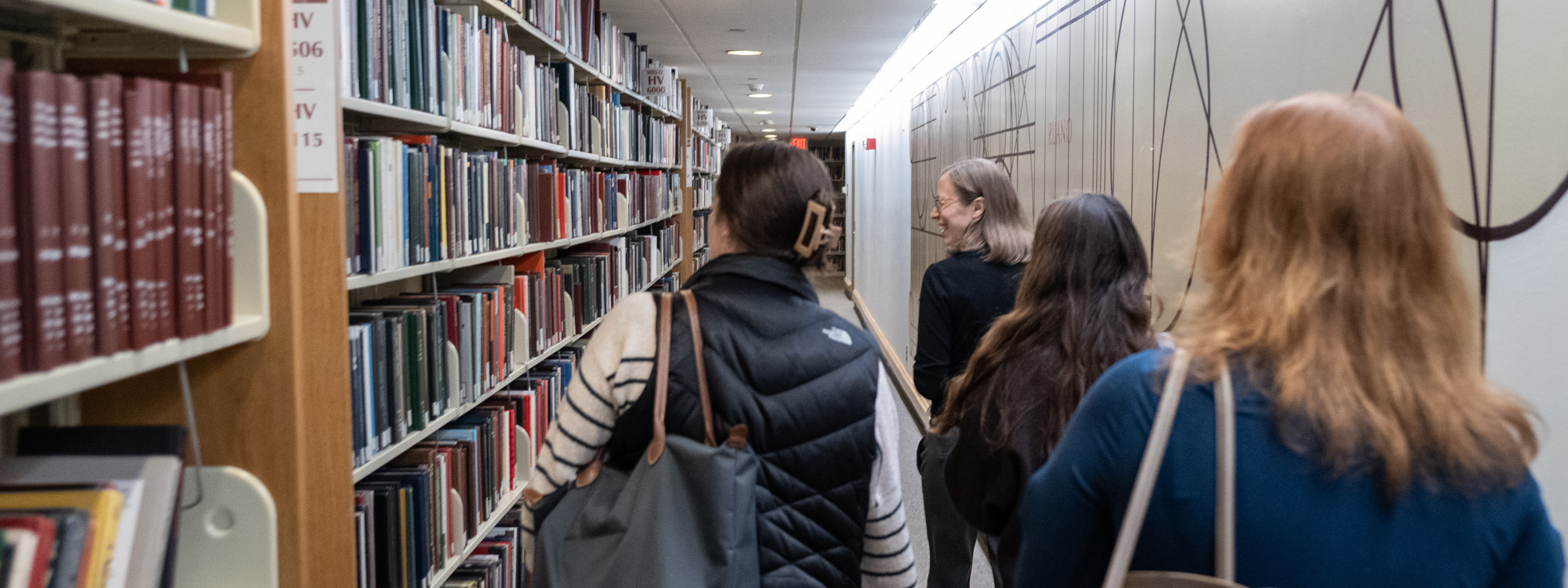 Fellows walking through a library.