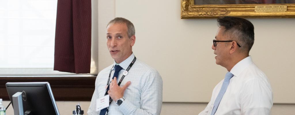 Two male teaching faculty giving a presentation at a podium.