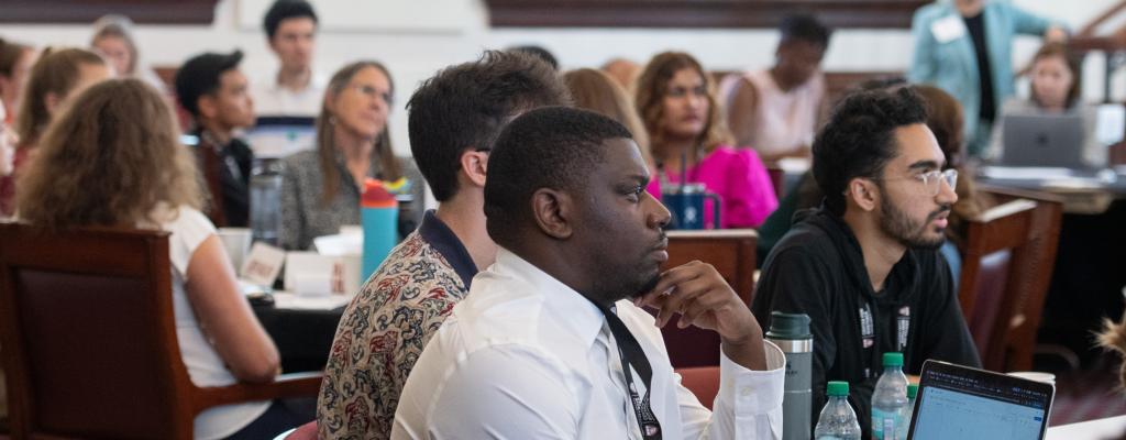 Closeup of male students in a group listening to a presentation.