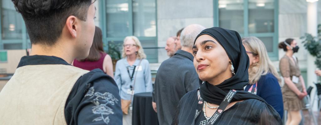 Closeup of two students chatting at a reception.