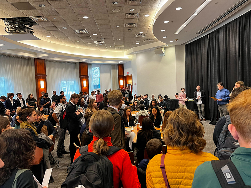 Participants standing in the crowd, looking at the stage, at the 2023 National Bioethics Bowl.