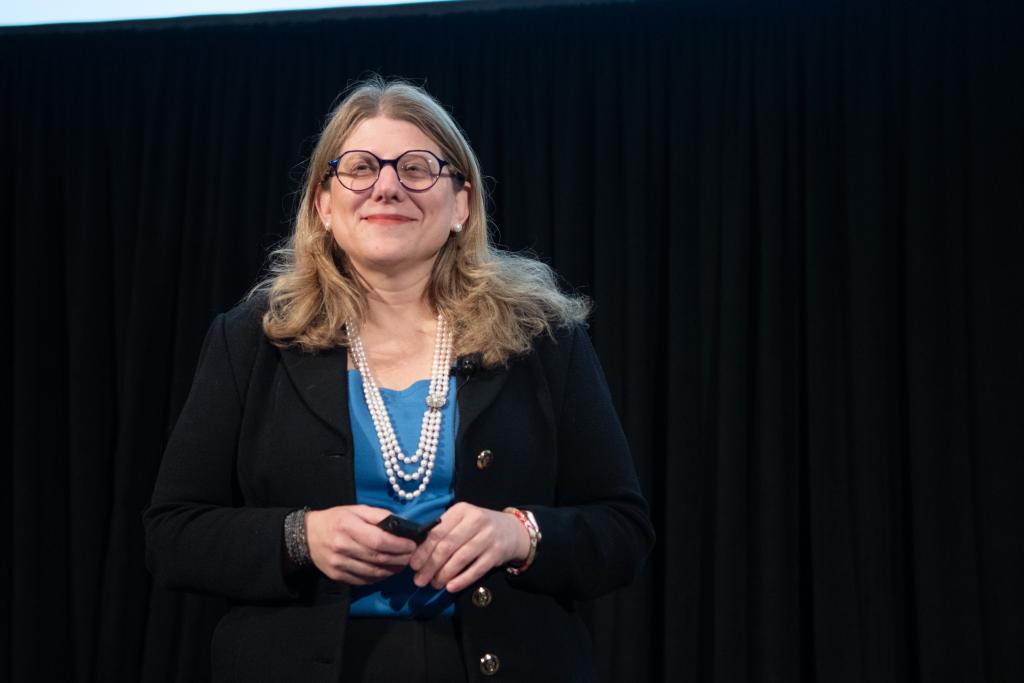 Rebecca Brendel smiling, standing on stage.