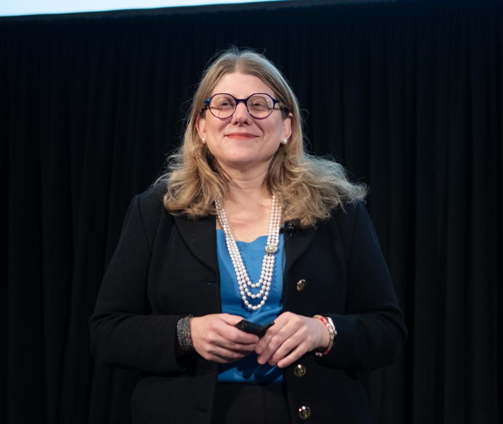 Rebecca Brendel smiling, standing on stage.