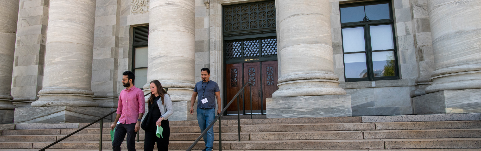 MBE students walking down the steps of Gordon Hall on a sunny day.