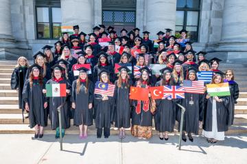 MBE grads holding country flags.