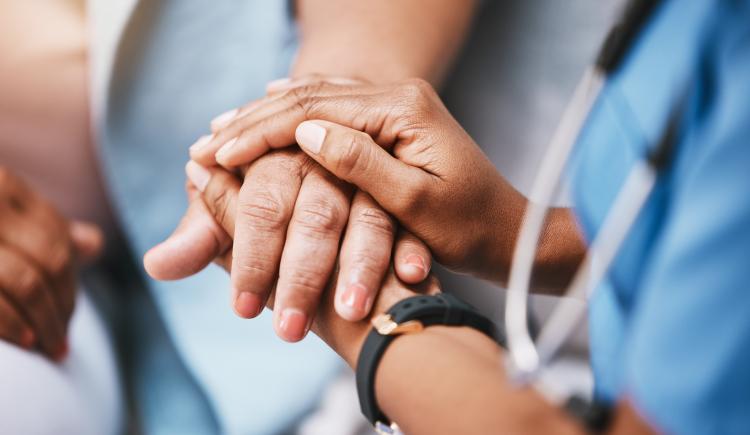 Nurse holding hands with patient.